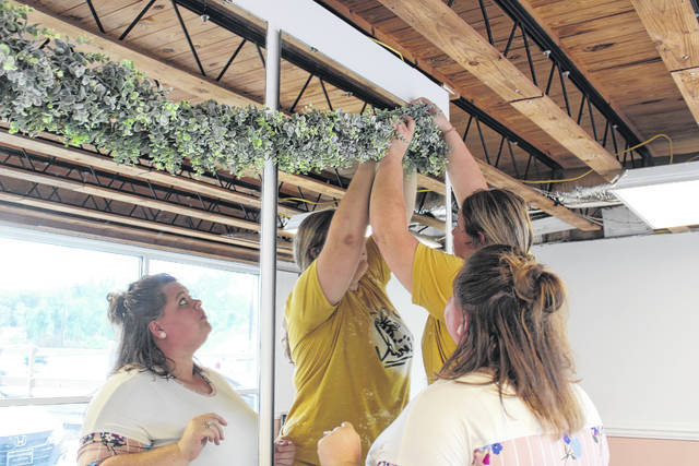 Hailey Howell adjusts the vines on her boutique walls. Howell and best friend Brittany Powell will open their business in October in Wadesboro. 
                                 Liz O’Connell | The Anson Record
