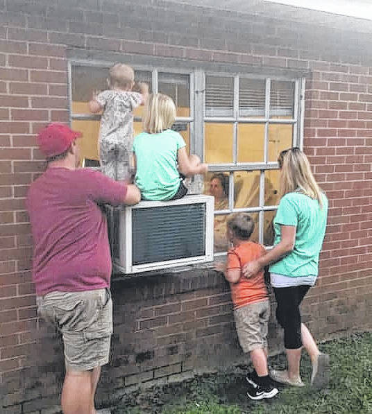 The Gillis family waves from the outside at the Wadesboro Health and Rehabilitation facility because of COVID-19 restrictions.