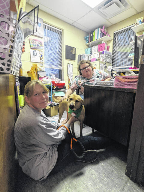 Jenny Wieczorek and Maureen Lett prepare a dog for rescue.