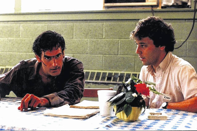 Ash Williams, played by Bruce Campbell, left, prepares to shoot a scene for Evil Dead (1981) in the then-operational J.R. Faison High School alongside director Sam Raimi.
                                 Contributed photo