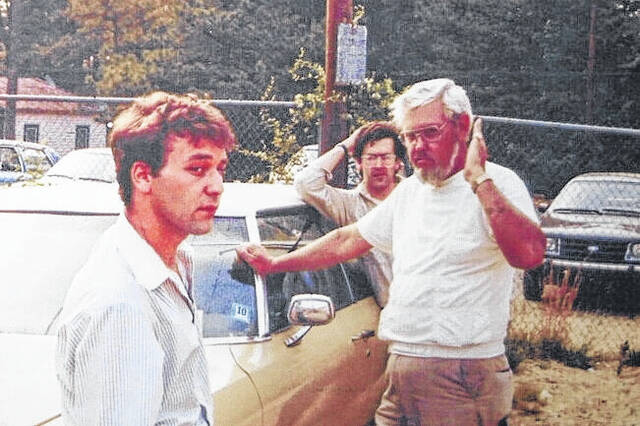 Sam Raimi, left, works with cast and crew outside of J.R. Faison High School; the house across the street is also still standing.
                                 Contributed photo