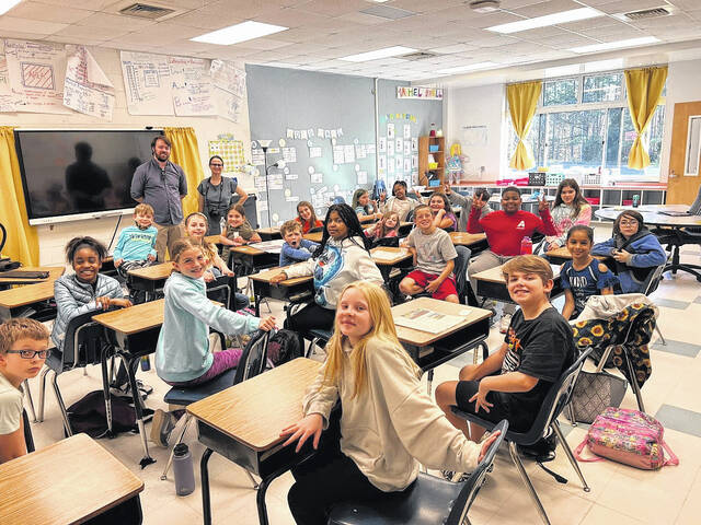 Anson Record News Editor Gavin Stone and Staff Writer Hannah Barron, standing center-left in the background, pose with a 4th grade class at Peachland-Polkton Elementary School after giving a presentation about what it means to be a journalist.
                                 Hannah Barron | Anson Record
                                Contributed photo