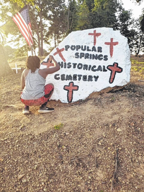 Youth Laila Hammond of the Burnsville Community brightening up the rock in front of the cemetery.
Photo courtesy of Carol Smith