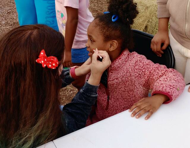 Talented artist Carli Gibson artfully painted a rainbow for Harmony Buchanon at the Face Painting Booth.