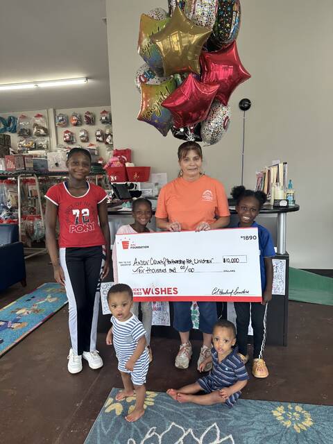 Partnership staff Karen Gerald and children take a break from playing in the Early Childhood Resource Room to celebrate receiving the KFC Wishes Grant for literacy initiative.
                                 Submitted photo