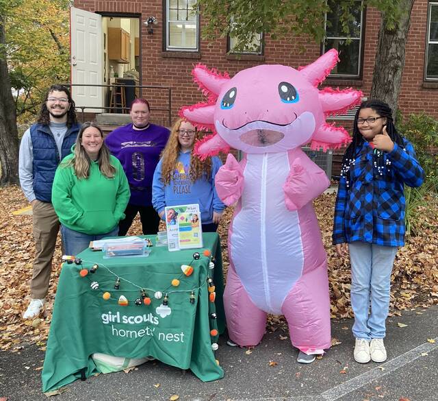 Caleb Lanye (troop co-leader), Melody Thompson (Council Representaive), Cynthia Hassell (troop product manager), Cheyenne Hassell and Zamya Chambers (Girl Scouts) pictured with Ace Rosada, this years troopcookie sale mascot, Axolotl (manned by Jessica Laney).
                                 Photo courtesy of Laura Laney
