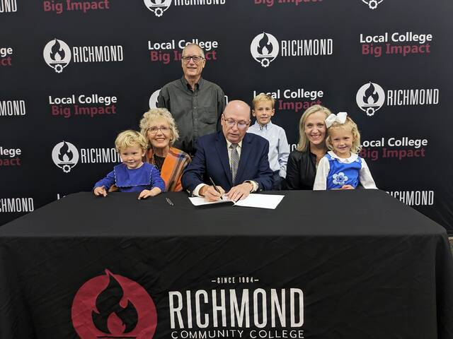 Dr. Dale McInnis, president of Richmond Community College, joins three generations of James Ralph McFaydens family to sign a scholarship established in his memory.
                                 Photo courtesy of RCC