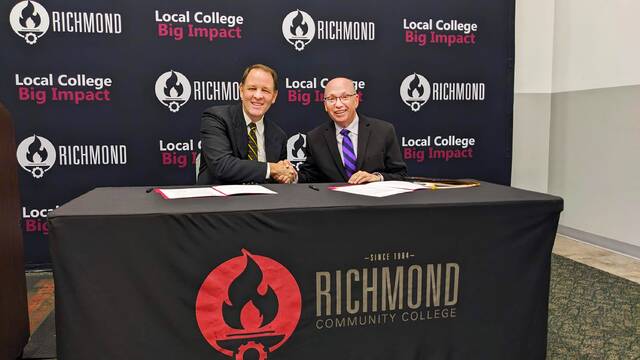 Dr. Scott Bullard, Pfeiffer University president, and Dr. Dale McInnis, Richmond Community College president, shake hands after signing off on Pfeiffer Pact, a guaranteed admission pathway for RichmondCC transfer students.
                                 Photo courtesy of RCC